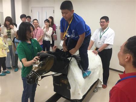 【競馬】[画像] 藤田菜七子騎手(21)が夏休み中の小中学生と共に木馬へまたがって熱心に騎乗指導「楽しいです」